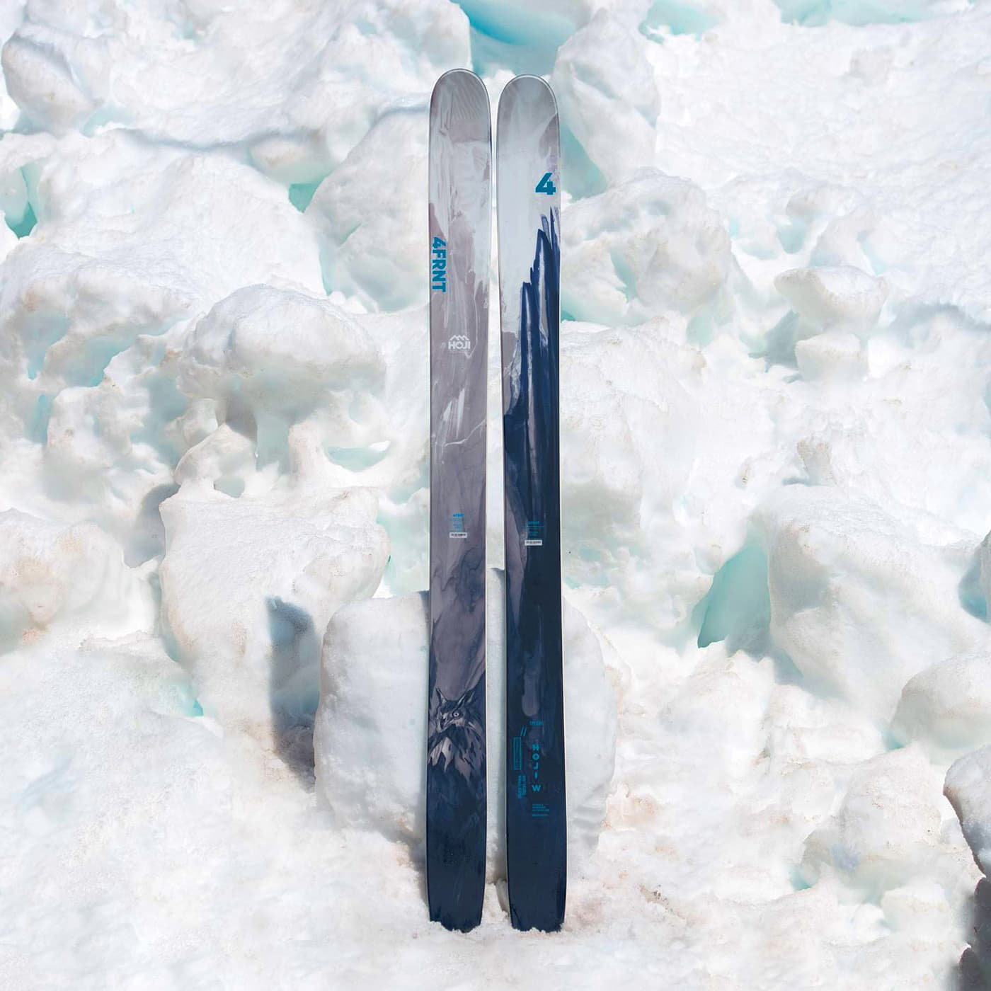 4FRNT Hoji W skis standing upright in snow with black, grey and ice blue graphics.