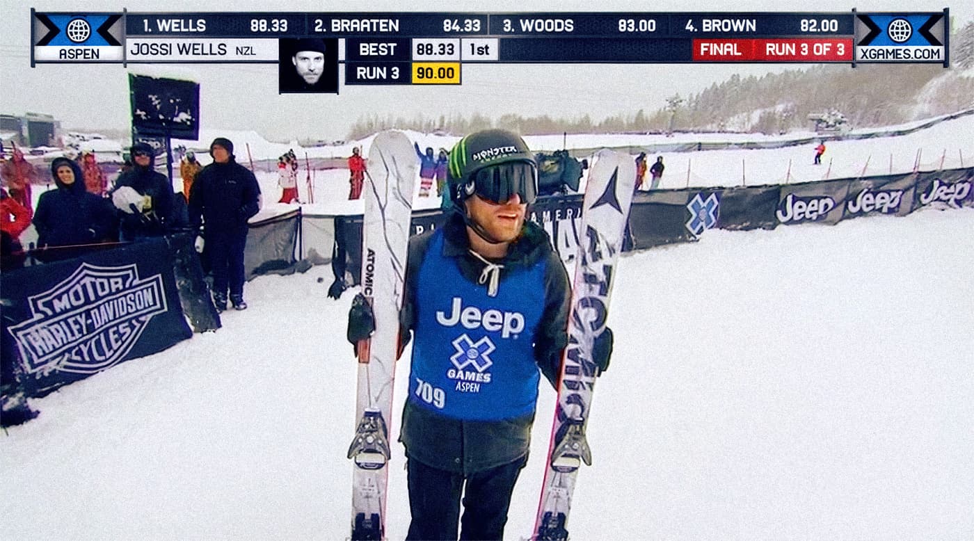 X Games broadcast still showing a skier holding Atomic Infamous skis with white marble-style graphics