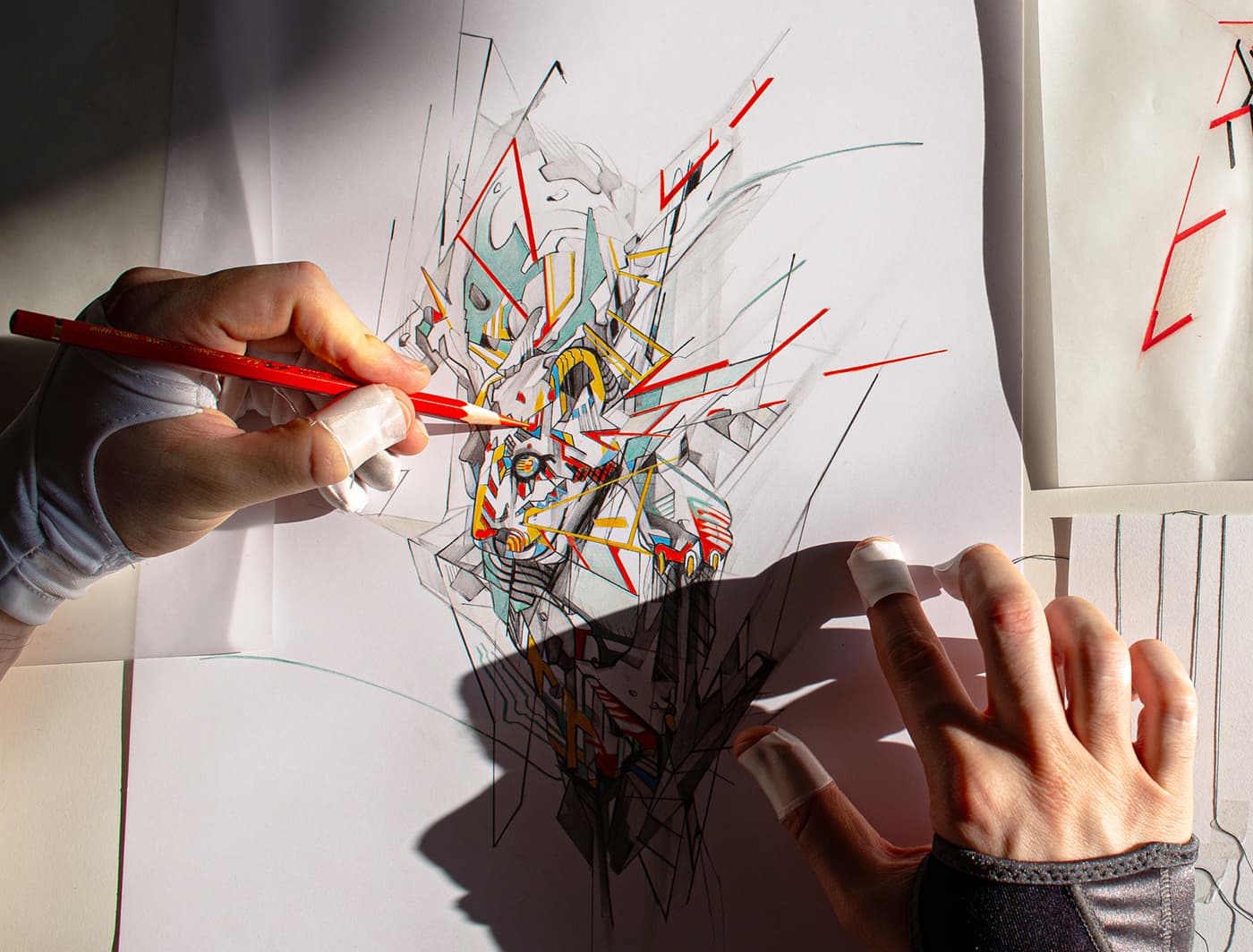 Hands adding red pencil details to the transformed leopard illustration, surrounded by thread and line studies.